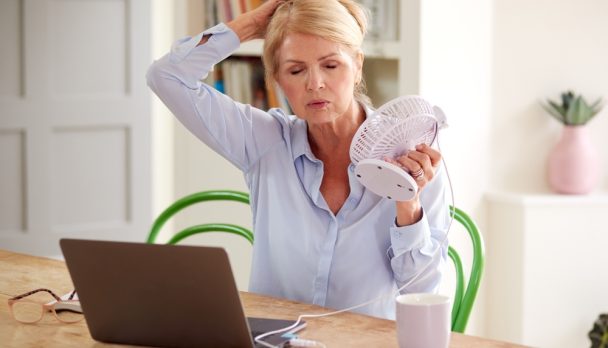 Menopausal,Mature,Woman,Having,Hot,Flush,At,Home,Cooling,Herself